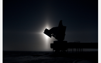 The 10-meter South Pole Telescope silhouetted against the glow of the moon