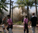 People running away from a tsunami-caused wave