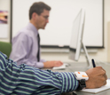 Photo of Brace prototype device on a hand and a person working on computer