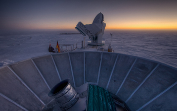 sun setting behind BICEP2 and the South Pole Telescope at Amundsen-Scott South Pole Station.