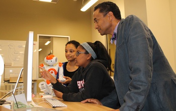 Andrew Williams with students and robot