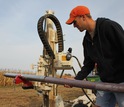 A scientist collects a sample for new soil carbon storage in a Midwest field crop.