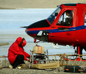 An engineer with AEM sensor next to helicopter