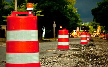 traffic cones on a road with potholes