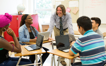 High school teacher and students in computer class