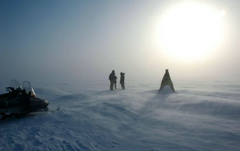 Researcher records snow/ice interface temperatures out on frozen surface of Elson Lagoon, Alaska