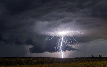 A cloud-to-ground lightning strike during a nighttime thunderstorm in the Midwest