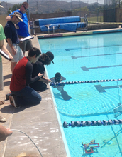 Sea Perch team members next to a pool where they test their remote operated vehicles