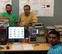 three scientists with computers and equipment in a lab