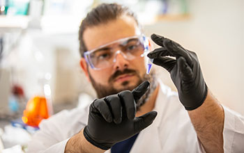 Researcher observes saliva sample from a ferret