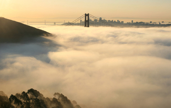 San Francisco's Golden Gate Bridge and Bay Bridge loom above a blanket of fog.