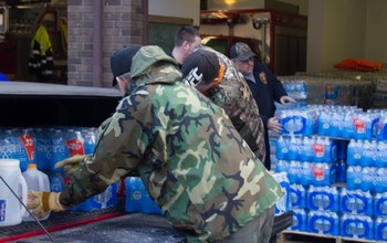 peeople unloading bottled water from truck to a storage place