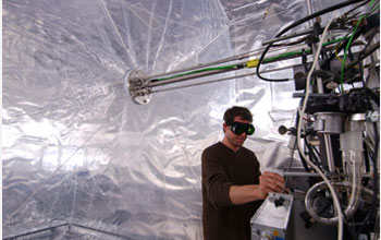 Photo of scientist fine-tuning instrumentation before an experiment in smog chamber in Switzerland.