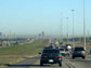 Photo of cars on a highway with smog in the distance.
