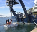 Researchers work on Alvin off the stern of the R/V Atlantis during sea trials off San Diego.