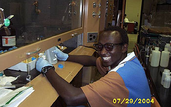 student works with lab equipment under hood