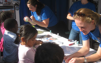 Photo of a EarthScope staffer with children at the USA Science and Engineering Festival.