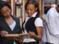 Photo of two female African American students holding an open book.