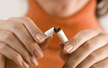 a woman breaking a cigarette.