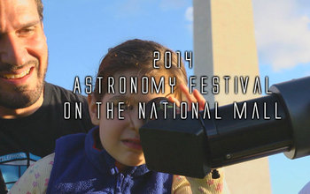 child looking through a telescope with washington monument in the background