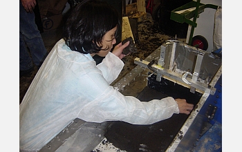 A team member lays peat from New Orleans into the centrifuge sample chamber.