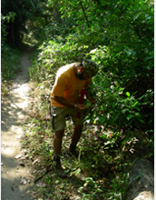 Photo of Jatinder Singh examining a plant in Tanzania's Mahale Mountains National Park.