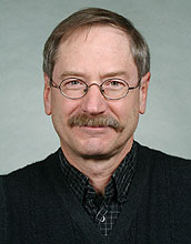 Scientist smiles at camera.