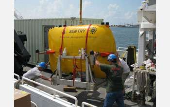 Photo of an autonomous underwater vehicle being loaded onto a research vessel.