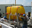 Photo of an autonomous underwater vehicle being loaded onto a research vessel.