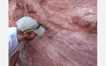 Photo of Patrick O'Connor examining exposed Pakasuchus bone fragments.