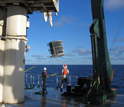 Photo of scientists on a research vessel sampling the South Pacific Ocean for microbes.
