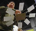 Photo of a boy raising a paper and cardboard helicopter model.