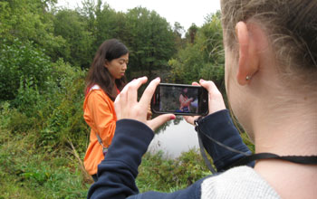 two students with a smart phone on a field trip