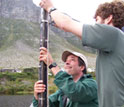 Photo of Curt Stager and Jay White retrieving a sediment core in a South African lake.