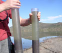 Photo of a scientist holding two sediment cores from South Africa's Lake Verlorenvlei.