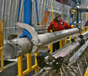Man standing next to a West Antarctic ice core barrel, at the site.