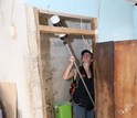 Researcher using a vacuum to trap mosquitoes in a bathroom