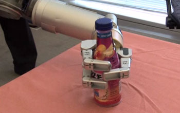 Barrett Technology's advanced robotic Whole Arm Manipulator carefully grasping a bottle.