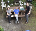 Photo showing bones of many large mammals on a groundcloth and three scientists.