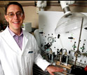 Benny Freeman stands next to the gas permeation system his team used in their research.