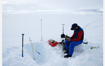 Photo of researcher Joel Harper making measurements on water flow through snow.