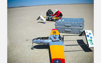 Research team members making adjustments to AUAVs, which carry miniature instruments.