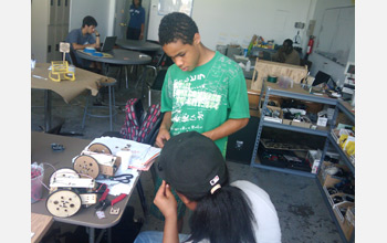 Photo of Jose working on his homemade robot.