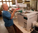 LTER scientist Kevin Kahmark next to equipment analyzing samples in the lab.