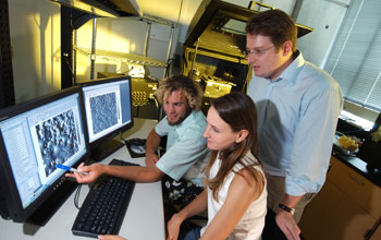 Photo of grad students and assistant professor working on nanometer-scale patterns on a computer