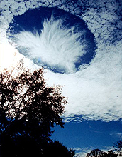 Above Alabama, hole-punch clouds dot the sky.