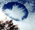 Above Alabama, hole-punch clouds dot the sky.