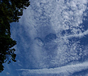 Hole-punch clouds appear over Norfolk, Va., with aircraft contrails leading from them.