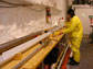 Photo of a person pushing an ice core out of the drill.