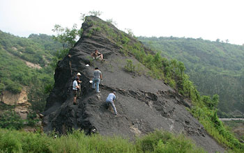 Photo of scientists collecting unweathered samples along a narrow road north of Beijing.